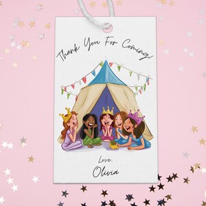 May include: A white thank you tag with a colorful illustration of five girls wearing crowns and sitting inside a tent. The text on the tag reads "Thank You For Coming! Love, Olivia."