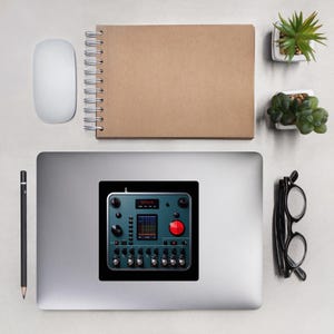 Puede incluir: Una pegatina con una consola de mezcla de audio turquesa y negra con un botón rojo. La pegatina está sobre un portátil, rodeada de un ratón, un cuaderno, un lápiz, gafas y pequeñas plantas en macetas. La consola tiene múltiples perillas y una pantalla.