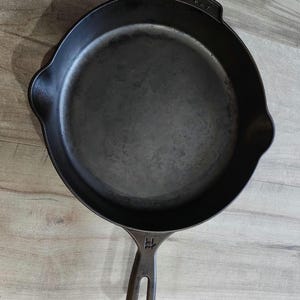 May include: A black cast iron skillet with a handle and the words "Butter Pat" embossed on the side.