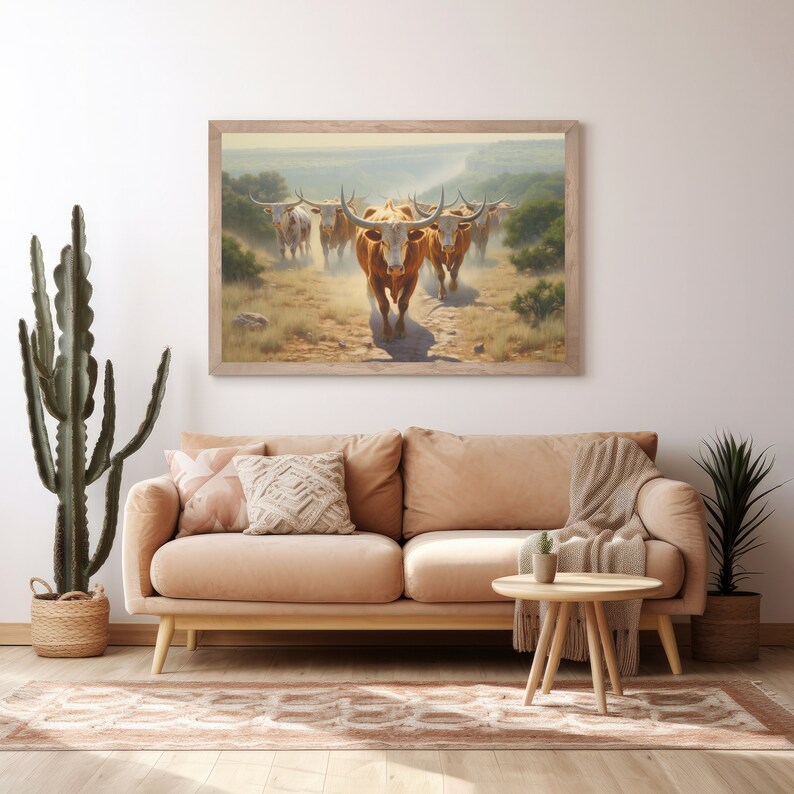 Puede incluir: Una pintura enmarcada de una manada de ganado de cuernos largos caminando a trav&eacute;s de un campo de hierba. El ganado es marr&oacute;n y blanco con cuernos largos. La pintura est&aacute; ambientada en un fondo de cielo azul y colinas onduladas.