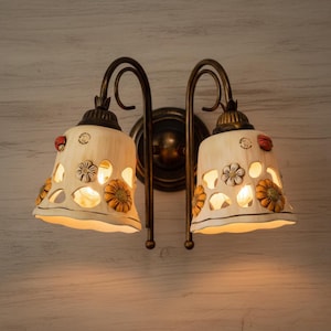 Two-light wall sconce in wrought iron and ceramic, handcrafted and decorated, Sofia collection.