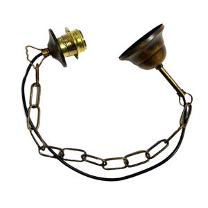 May include: A brass chain with a black wire and a brass socket and a brass ceiling canopy.