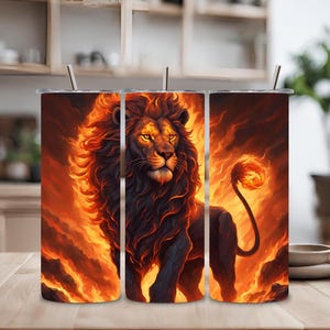 Puede incluir: Tres vasos de acero inoxidable con un diseño de un león negro con una melena y cola de fuego. El león está de pie sobre un fondo naranja y amarillo ardiente.