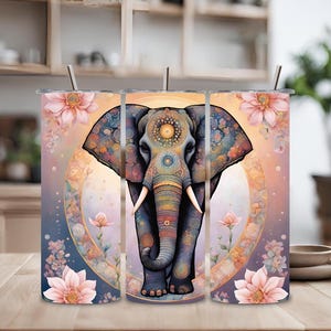 Puede incluir: Tres vasos de acero inoxidable con un diseño de mandala colorido que presenta un elefante con acentos florales. Los vasos son de color rosa claro, azul claro y amarillo claro.