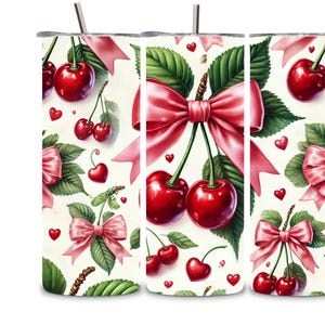 Puede incluir: Un vaso blanco con un patrón de cerezas rojas, hojas verdes y lazos rosas. El vaso está diseñado para bebidas calientes o frías.