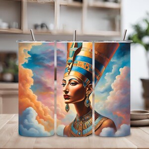 Puede incluir: Tres vasos de acero inoxidable con una imagen colorida de una reina egipcia con una corona dorada y un tocado azul y dorado. El fondo es un cielo de puesta de sol colorido con nubes.