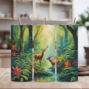 Puede incluir: Tres vasos de acero inoxidable con una escena de jungla con ciervos y vegetación exuberante. Los vasos son de un verde, azul y marrón vibrantes con un patrón floral colorido.