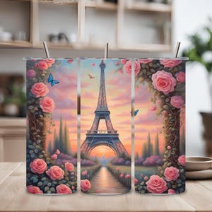 Puede incluir: Tres vasos de acero inoxidable con un diseño de la Torre Eiffel en París, Francia. El diseño incluye rosas rosas y mariposas. Los vasos son perfectos para disfrutar de su bebida favorita.