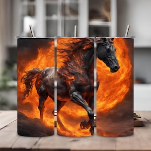 Puede incluir: Tres vasos de acero inoxidable con un caballo negro corriendo a través de las llamas. El caballo está en el centro de la imagen y las llamas son de color naranja y amarillo.