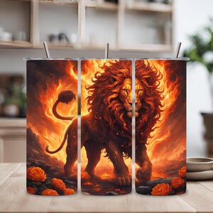 Puede incluir: Tres vasos de acero inoxidable con un diseño de un león de pie en llamas. El león es naranja y marrón con una melena espesa. Las llamas son naranja y amarillas.