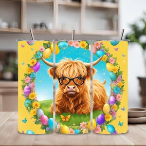 Puede incluir: Un vaso amarillo con una vaca de las Tierras Altas con gafas, rodeada de un diseño de corona de Pascua con huevos y flores. El vaso tiene una pajita y es adecuado para bebidas frías. El diseño incluye mariposas y un cielo azul.