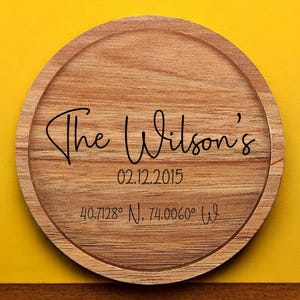 May include: A round wooden coaster with the text "The Wilson's" engraved on it. The date "02.12.2015" and coordinates "40.7128&deg; N, 74.0060&deg; W" are also engraved on the coaster.