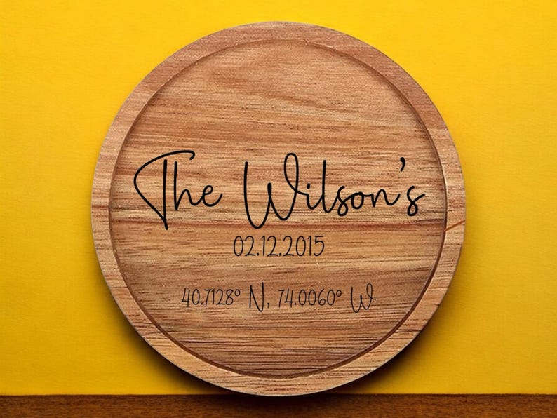 May include: A round wooden coaster with the text "The Wilson's" engraved on it. The date "02.12.2015" and coordinates "40.7128&deg; N, 74.0060&deg; W" are also engraved on the coaster.