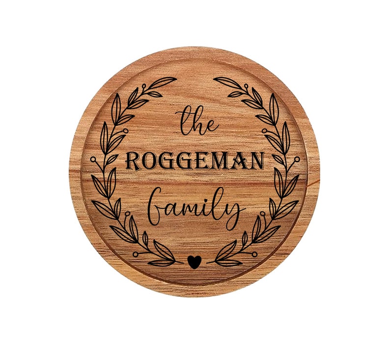 May include: A round wooden sign with a wreath of leaves and the text "The Roggeman Family" in black lettering.