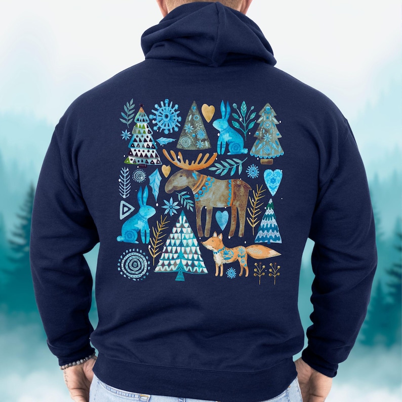 May include: Navy blue hoodie featuring a watercolor design of woodland creatures and trees. The design includes a moose, fox, rabbits, and stylized trees in shades of blue, gold, and brown. The hoodie has a drawstring hood and a kangaroo pocket.