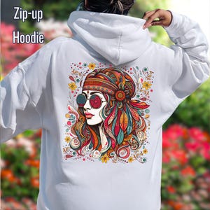 May include: White zip-up hoodie featuring a colorful illustration of a woman with round sunglasses, a headband, and feathers. The design includes floral and paisley elements. The text "Zip-up Hoodie" is at the top left.