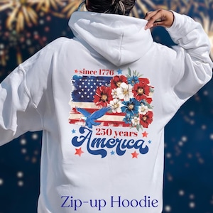 May include: White zip-up hoodie featuring a patriotic design. The back displays an American flag with red, white, and blue floral accents, a blue eagle, and the text "since 1776" and "250 years America".