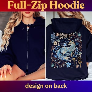 May include: A navy blue full-zip hoodie with a design on the back featuring a blue fox in a floral pattern. The hoodie has a drawstring hood and a zipper closure.