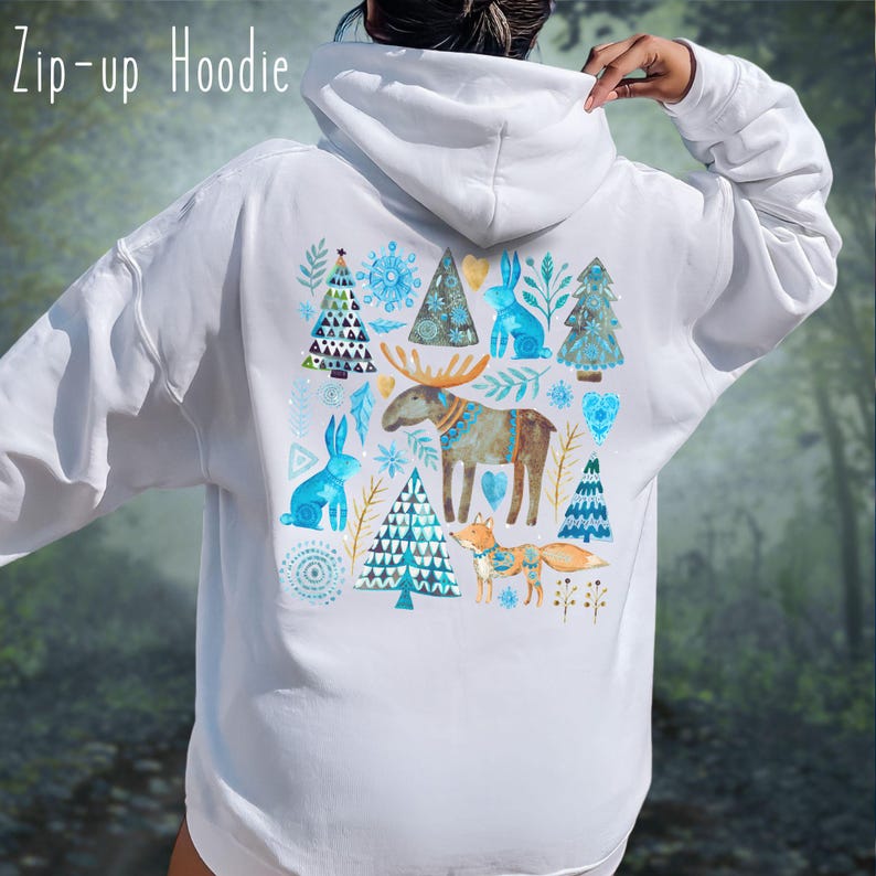 May include: White zip-up hoodie with a colorful winter-themed design on the back. The design features blue rabbits, trees, snowflakes, a moose, and a fox. The text "Zip-up Hoodie" is at the top left.
