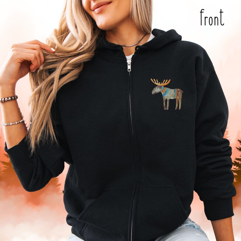 May include: Black zip-up hoodie with a watercolor moose graphic on the chest. The moose has brown antlers and a colorful patterned body. The word "front" is printed in black on the upper right side of the hoodie.