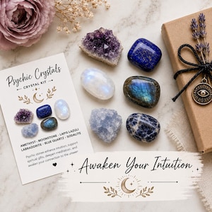 May include: A crystal kit with the text "Psychic Crystals" and "Awaken Your Intuition". The kit includes amethyst, moonstone, lapis lazuli, labradorite, blue quartz, and sodalite crystals. A gift box with a dried lavender bundle is also present.