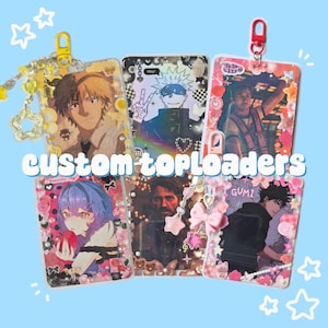 May include: Five rectangular plastic card holders decorated with various anime and character prints, colorful beads, charms, and stickers. Each holder features a clip at the top for attachment, with some including dangling star and heart-shaped charms.