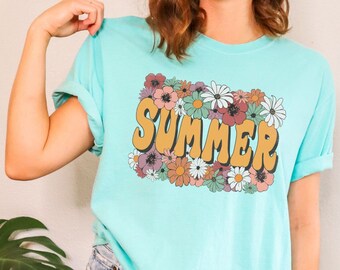 May include: A turquoise blue t-shirt with a floral design and the word "SUMMER" in yellow letters.