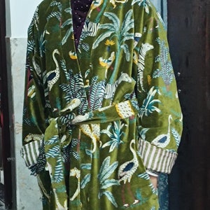 May include: A green velvet robe with a tropical print featuring zebras, birds, and palm trees.