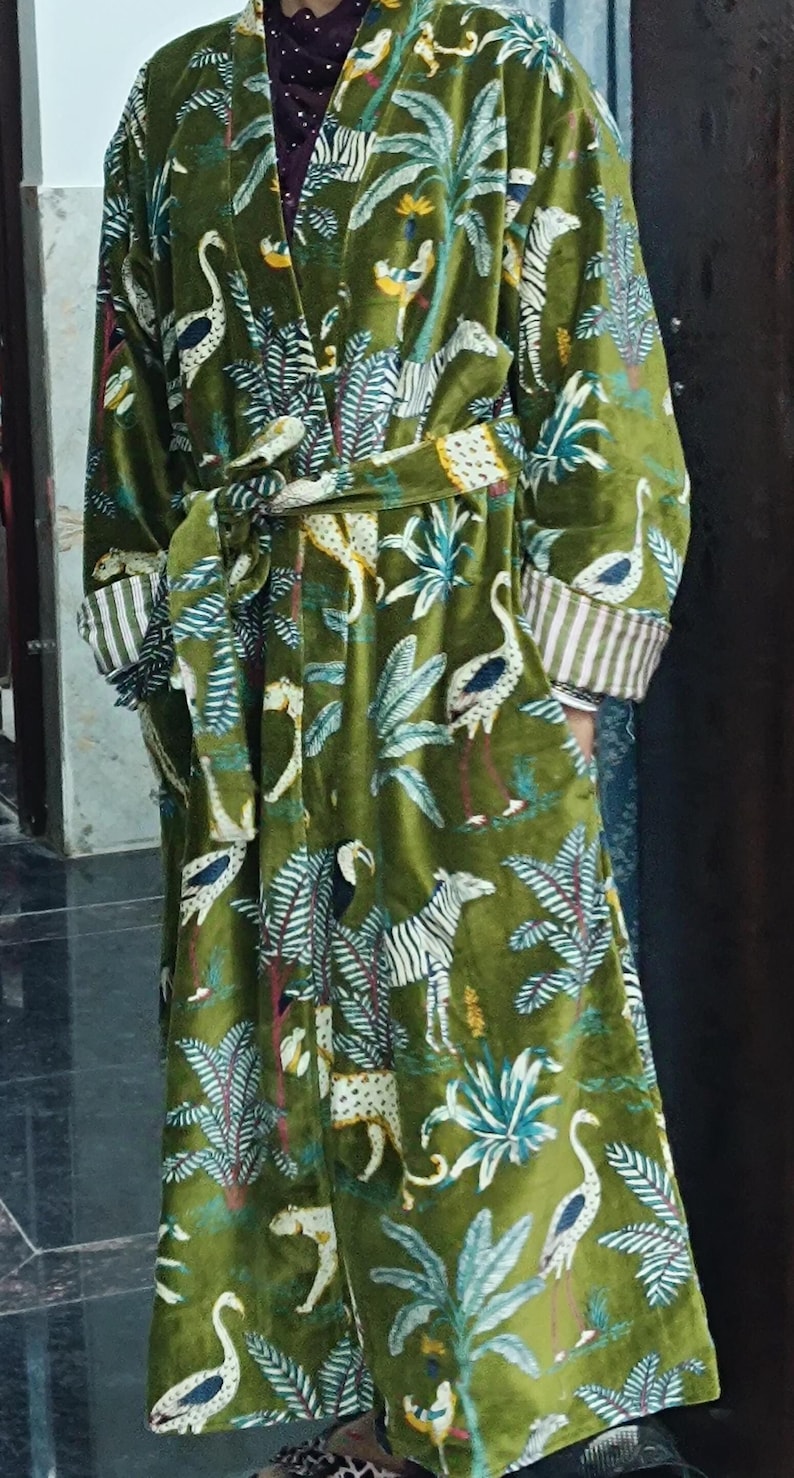 Puede incluir: Una bata de terciopelo verde con estampado tropical de cebras, p&aacute;jaros y palmeras.