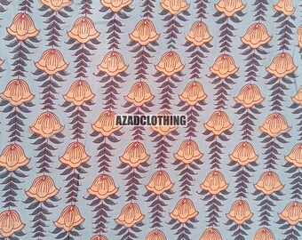 May include: A light blue fabric with a repeating pattern of orange flowers with red outlines and dark green leaves. The text "AZADCLOTHING" is printed in the center of the fabric.
