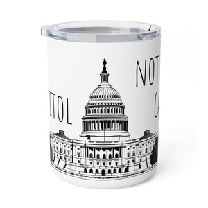 May include: White travel mug with a black and white depiction of the U.S. Capitol building. The words "NOT CAPITOL" are printed in black. The mug has a clear plastic lid.