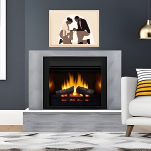 May include: A modern electric fireplace with a black frame and a realistic log set. The fireplace is built into a grey stone surround and is set against a dark grey wall. A framed print of a couple kneeling in prayer hangs above the fireplace.