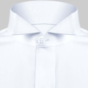 May include: A white dress shirt with a button-down collar and a single button closure.