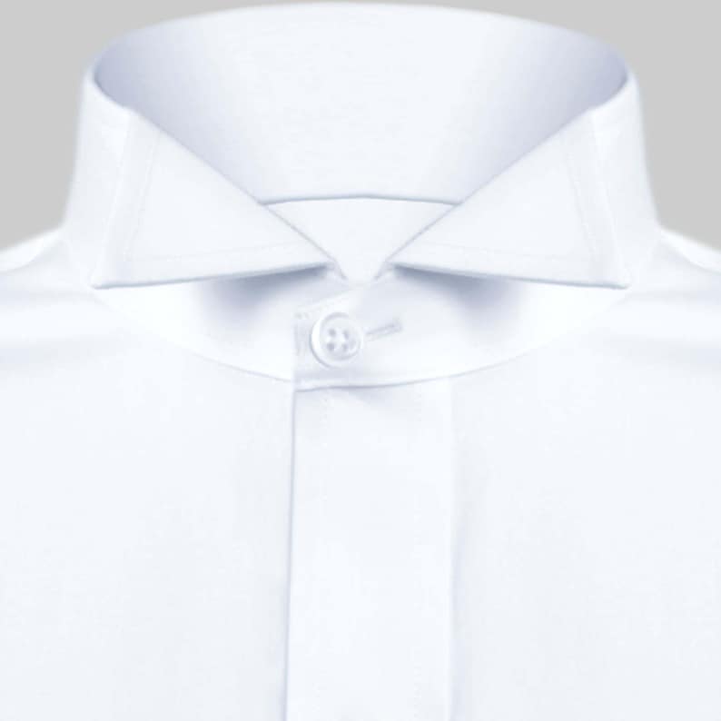 May include: A white dress shirt with a button-down collar and a single button closure.