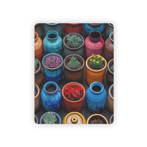 May include: A colorful puzzle featuring a variety of small, ceramic pots filled with plants and flowers. The pots are in shades of blue, orange, red, and brown, with a variety of plants, including succulents and flowering plants.