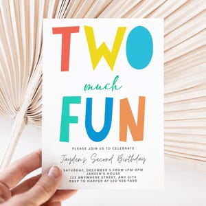 以下が含まれることがあります： カラフルなブロックレターで「TWO much FUN」と書かれた白い招待状。カードには、日付、時間、場所、RSVP情報など、ジェイデンの2歳の誕生日に関する詳細も含まれています。