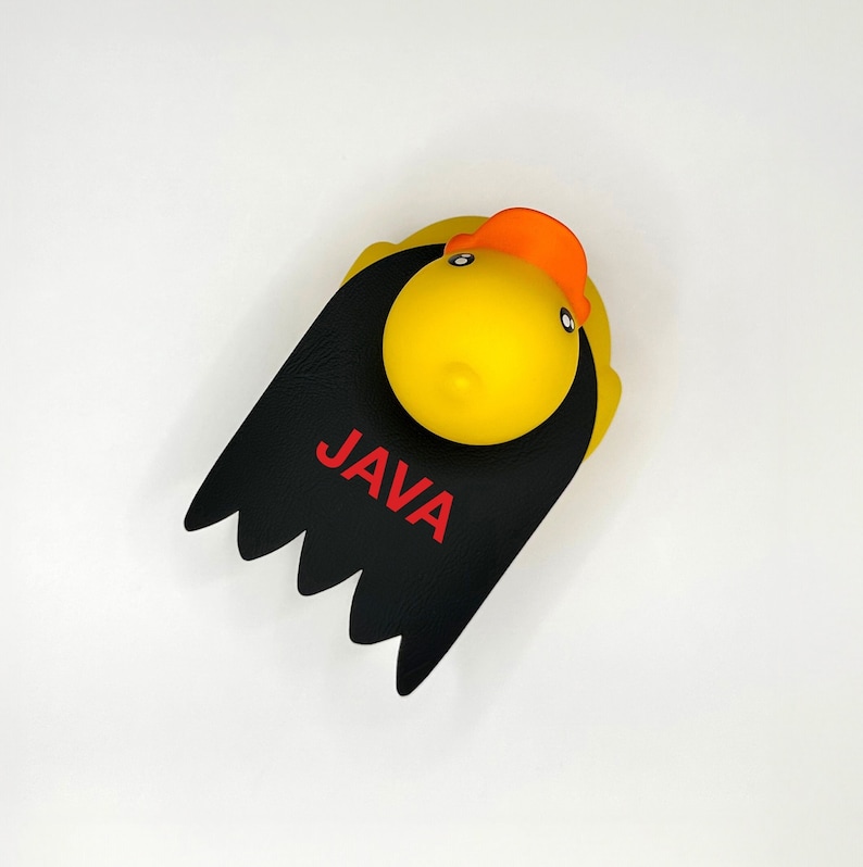 May include: A yellow rubber duck with a black cape and the word "JAVA" written in red letters.