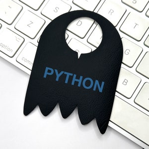 Op de afbeelding: Een zwarte leren deurhanger met een uitsparing voor een deurknop en het woord "PYTHON" in blauwe letters.