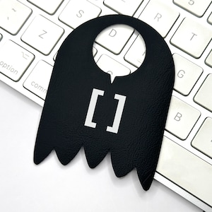 May include: Black door hanger with a white square containing the text "[]".