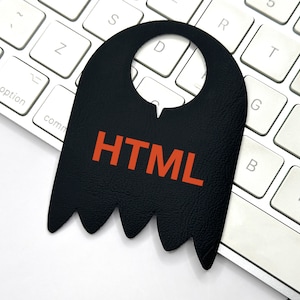 May include: A black leather door hanger with a cut-out for a door knob. The hanger has a jagged bottom edge and the word "HTML" written in orange letters.