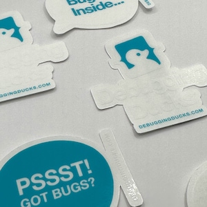 May include: A set of four teal blue and white stickers with the text "Bugs Inside...", "Pssst! Got Bugs?", and "Debugging Ducks.com". One sticker features a cartoon duck with a speech bubble.