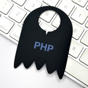 Puede incluir: Un colgador de puerta de cuero negro con un recorte para un pomo de puerta y la palabra "PHP" en texto azul.