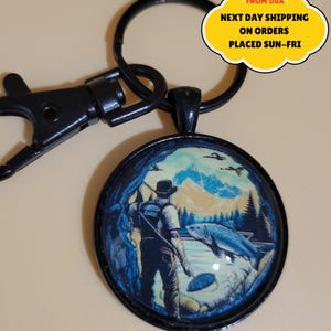 Llavero con cabujón de cristal de 30 mm de salmón pescador, color negro, con anilla partida y cierre de mosquetón.