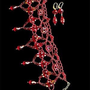 May include: A red beaded necklace and earrings set. The necklace is a delicate, intricate design with dangling beads. The earrings are simple teardrop shapes.
