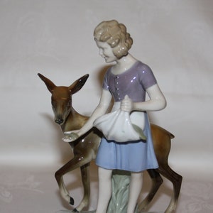 A figurine of a girl feeding a baby horse from her hand, a vintage German porcelain with adorable, real expression