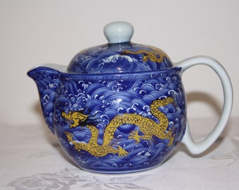 A Chinese teapot with dragon pattern, a practical tea time item with a metal sieve