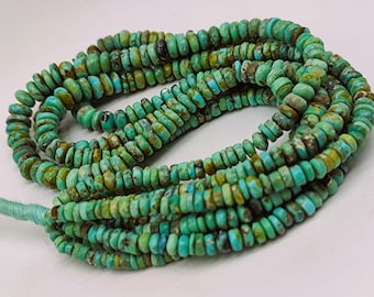 May include: Strands of turquoise beads in varying shades of blue and green. The beads are small, flat, and disc-shaped, strung together to form multiple strands. The beads have a natural, earthy appearance, with variations in color and texture.