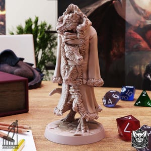 Puede incluir: Figura de fantasía de color marrón claro de una criatura parecida a un dragón que lleva un abrigo largo con ribete de piel. La figura tiene un diseño detallado, incluyendo escamas, garras y un cinturón. La base es una plataforma circular.