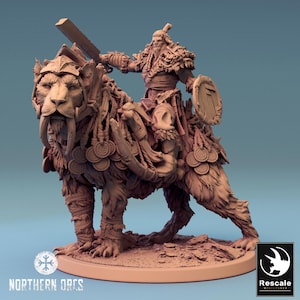 May include: A detailed miniature figure of a warrior riding a saber-toothed tiger. The warrior is clad in fur and armor, wielding a large blade and shield. The tiger is adorned with decorative elements. The base features the text "Northern Orcs."