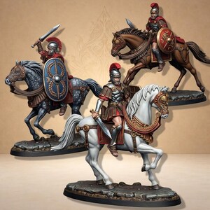 Op de afbeelding: Miniatuurbeeldjes van Romeinse soldaten te paard. De figuren zijn in volledige bepantsering, met zwaarden en schilden. De paarden hebben verschillende kleuren, waaronder grijs, bruin en wit. De soldaten dragen rode en zilveren bepantsering en helmen.